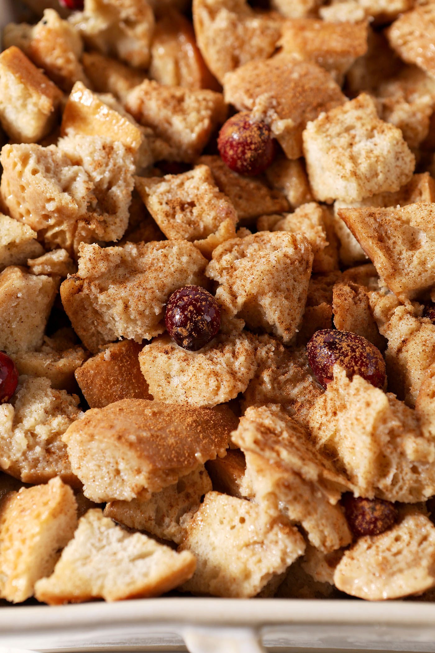 Cranberry French Toast Casserole after its overnight soak and being sprinkled with extra cinnamon