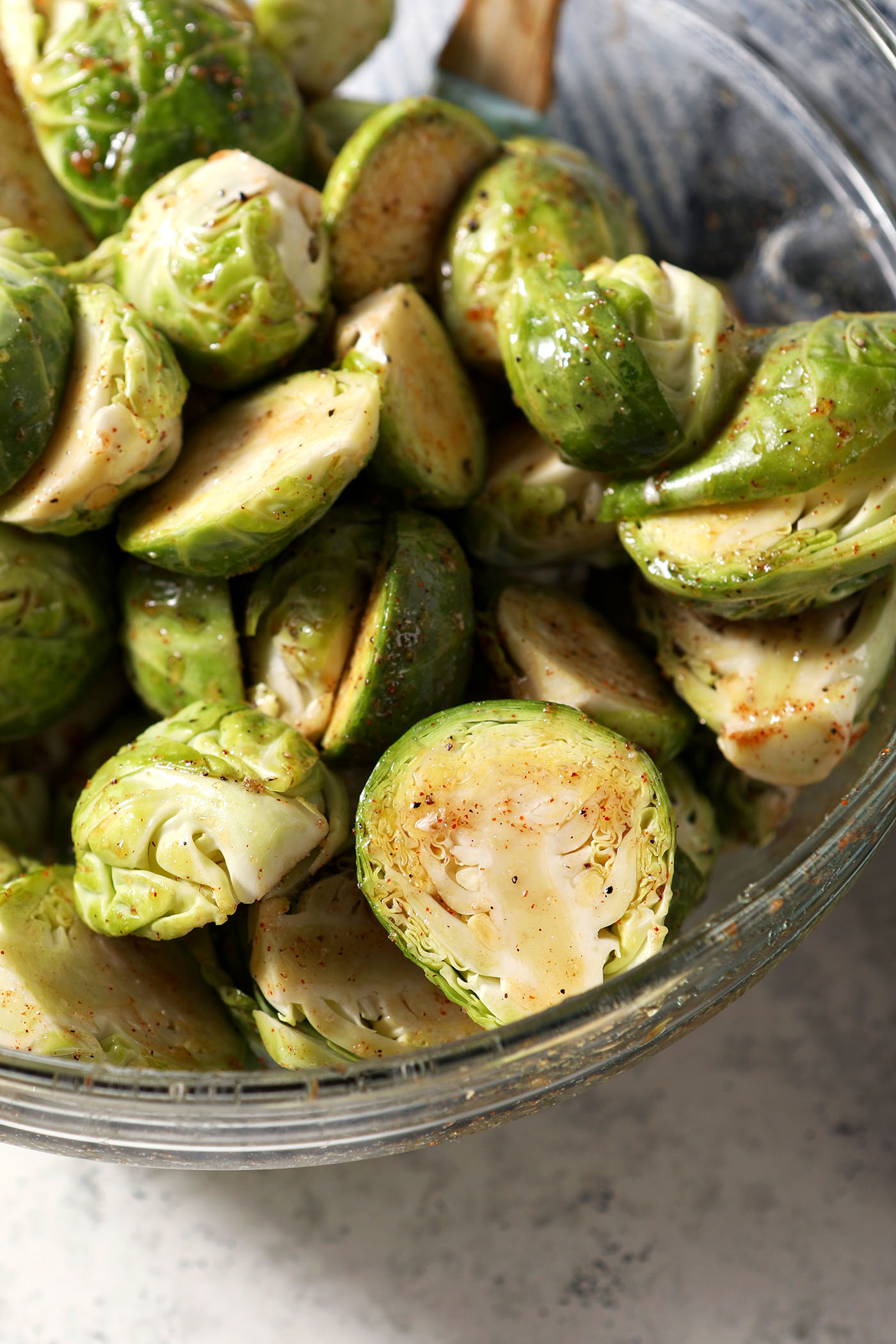 Close up of seasoned brussels sprouts before roasting