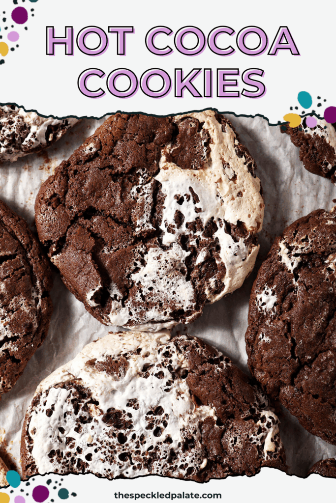 A sheet pan of baked chocolate marshmallow cookies, surrounded by marshmallows and chocolate chips with the text hot cocoa cookies