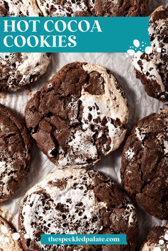 A sheet pan of baked chocolate marshmallow cookies, surrounded by marshmallows and chocolate chips with the text hot cocoa cookies
