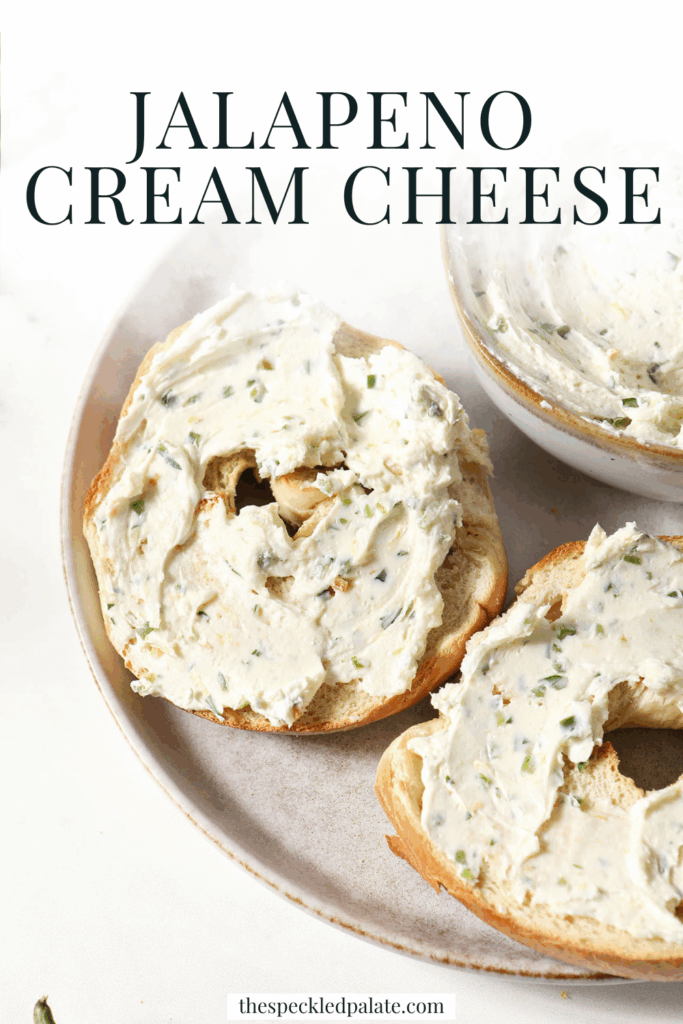 Bagel halves slathered in Jalapeno Cream Cheese on a grey plate on a marble surface