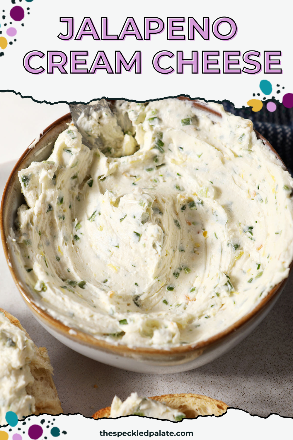 Close up of a bowl of jalapeño cream cheese on a marble surface next to a blue linen with the text Jalapeno Cream Cheese