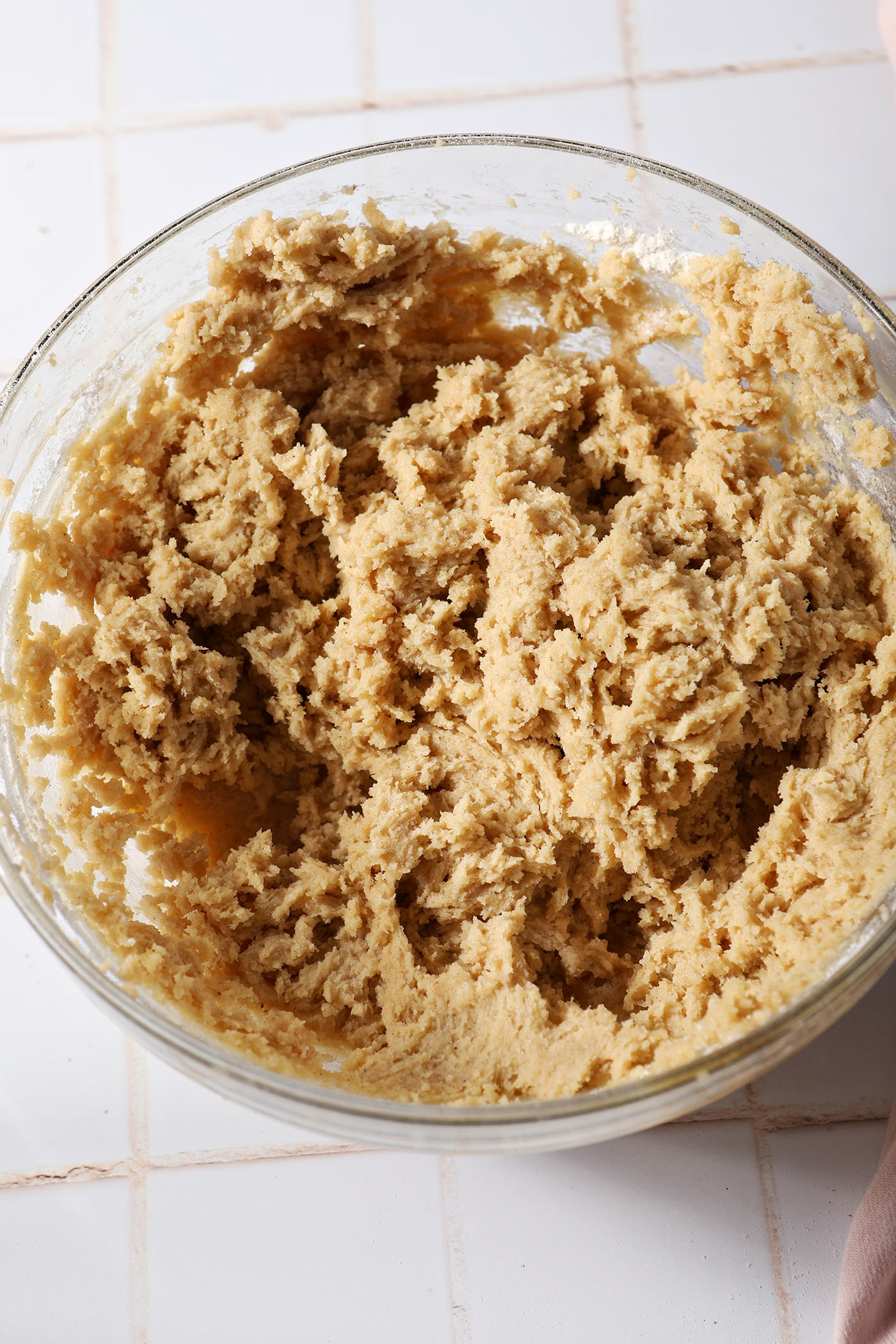 Cookie dough in a bowl on a white tiled surface