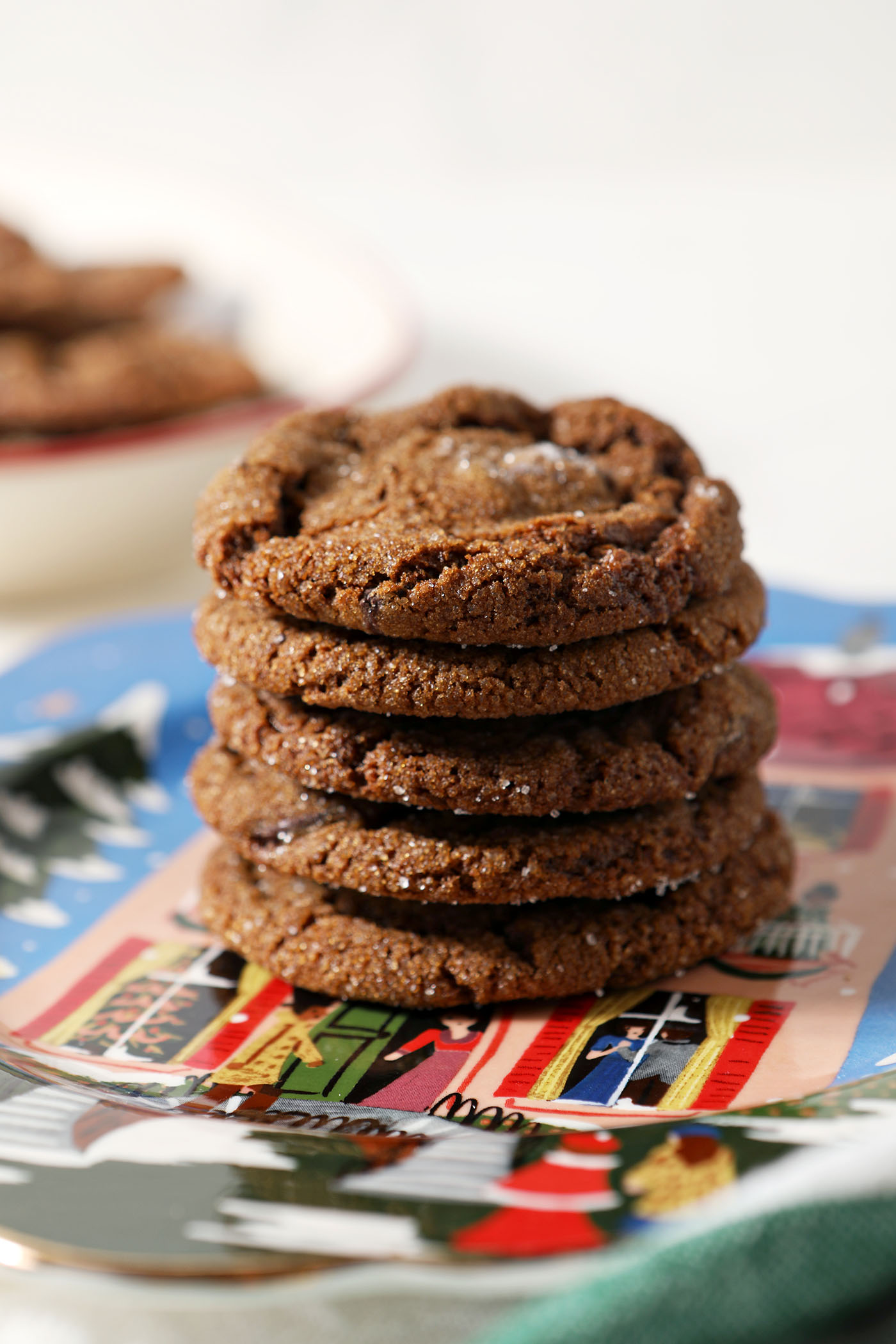 A stack of chocolate gingerbread cookies on a holiday plate