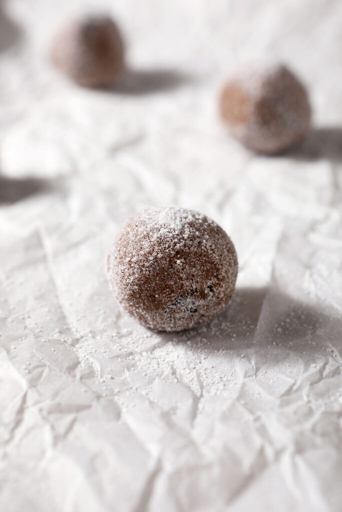 Chocolate gingerbread cookie dough balls on parchment paper, before baking