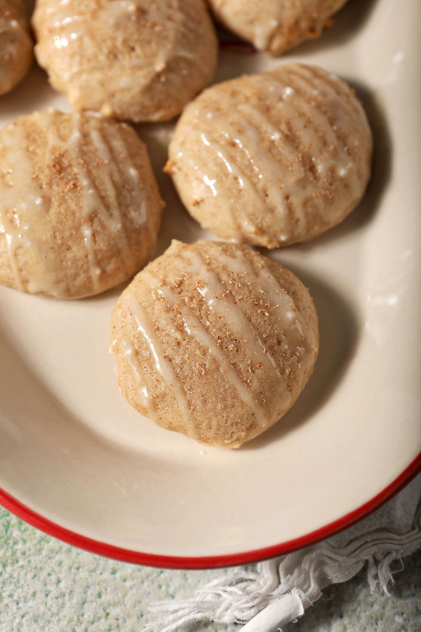 Close up of a platter of eggnog cookies topped with an eggnog icing drizzle