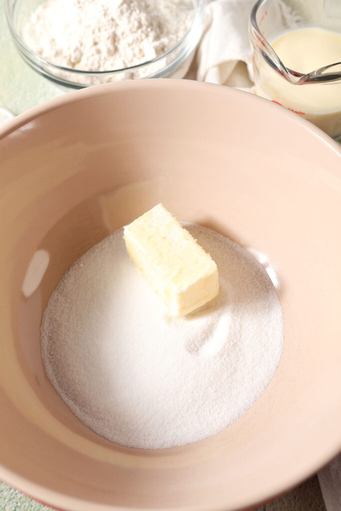 A half stick of butter and granulated sugar in a bowl, before mixing