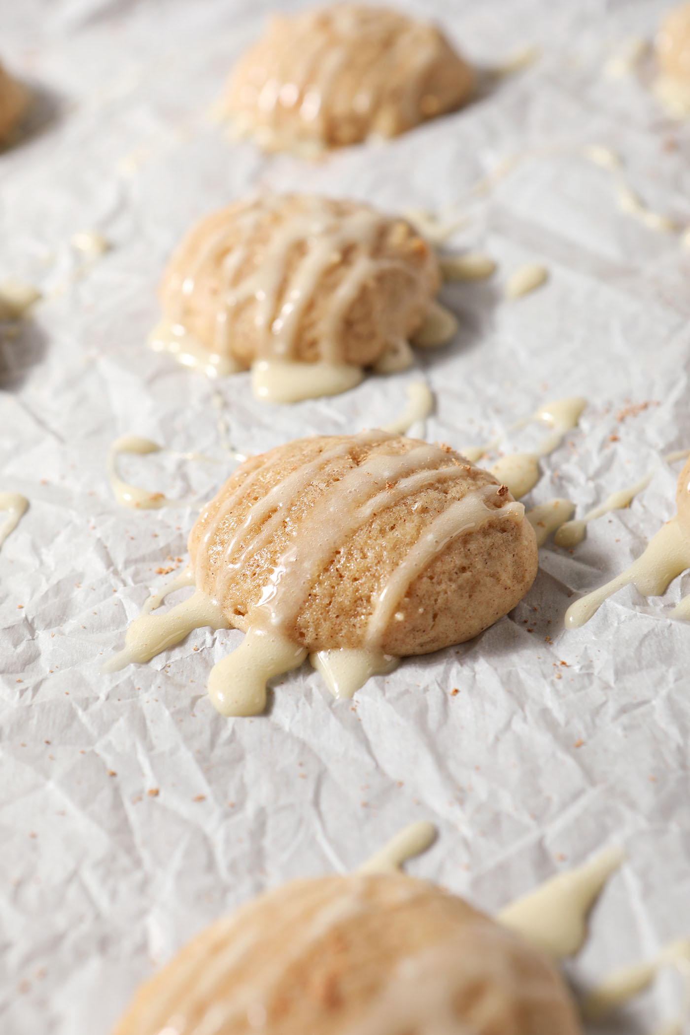 Eggnog cookies drizzled with an eggnog icing glaze on a sheet pan