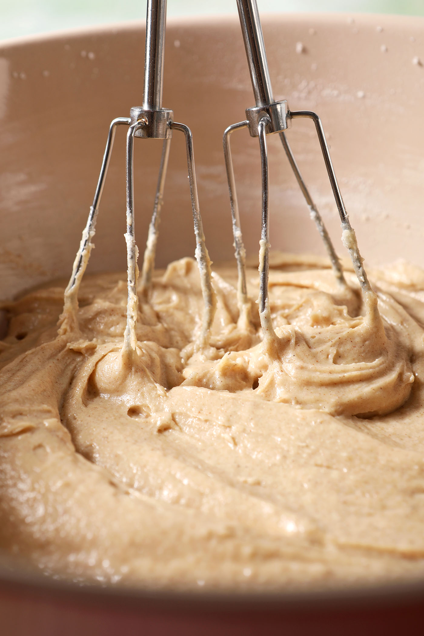 A hand mixer in cookie dough in a bowl