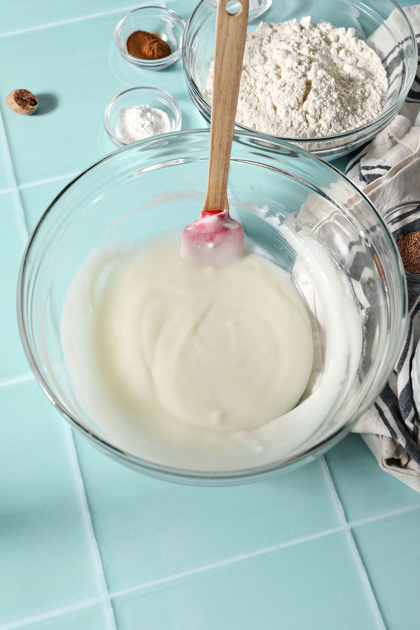 Whipped sour cream and sugar in a bowl on a green tiled surface