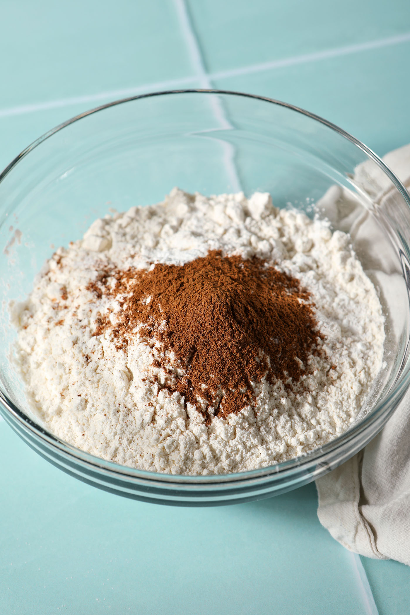 dry ingredients for muffins in a bowl on a green tiled surface