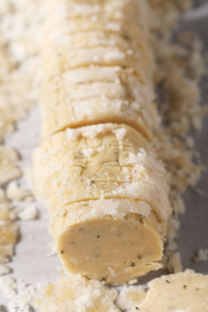 Sliced rosemary ginger cookies on parchment before baking