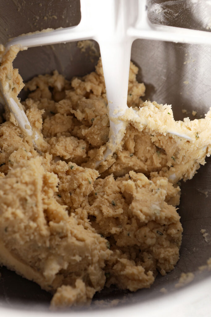 Shortbread cookie dough in a metal stand mixer bowl with the paddle attachment