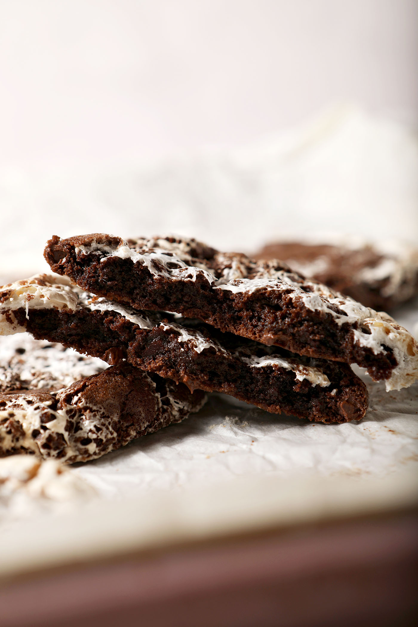 A halved hot chocolate cookie on a sheet pan near other cookies