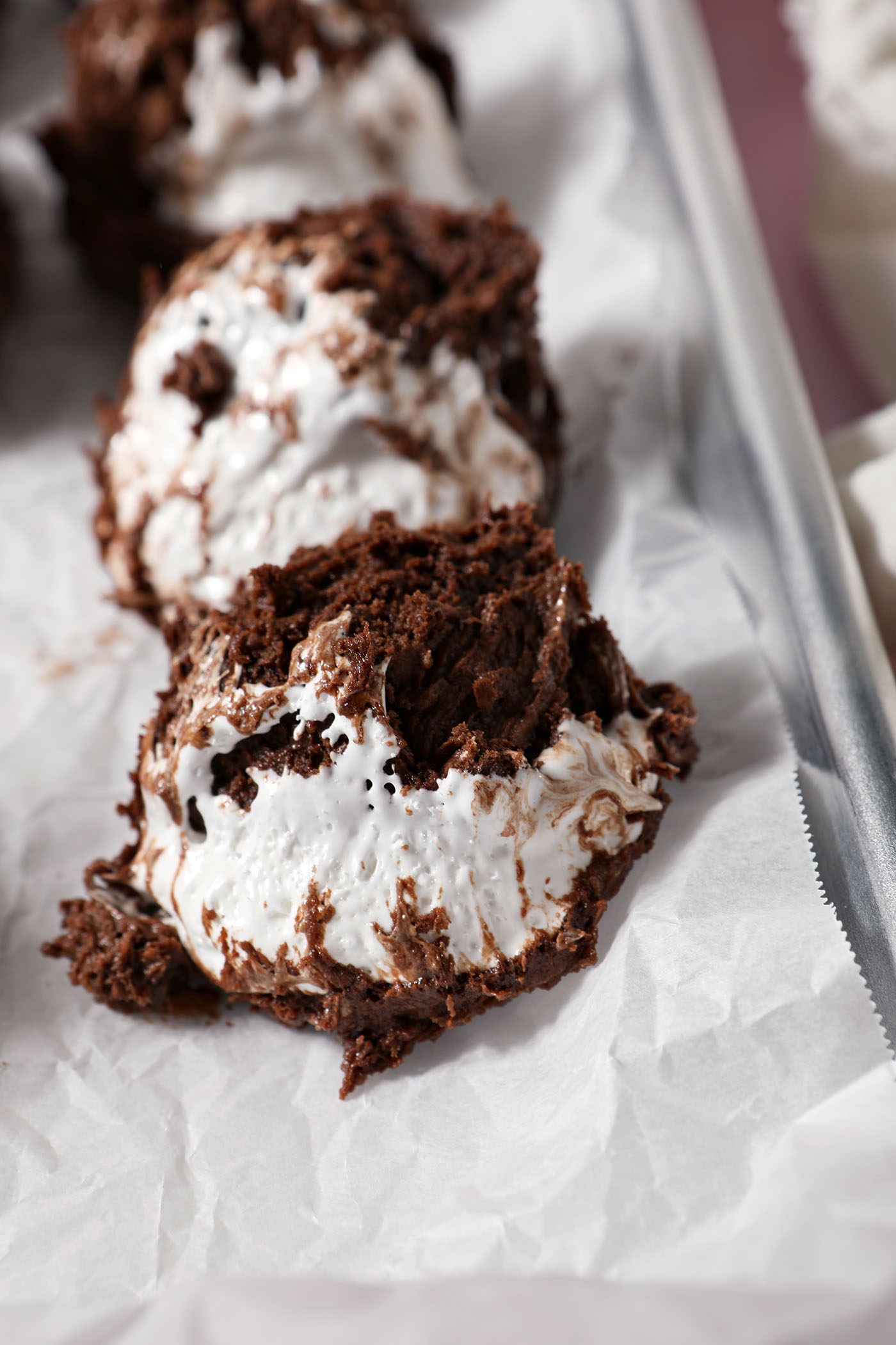 Hot cocoa cookies after scooping lined up on a parchment-lined sheet pan before cooling