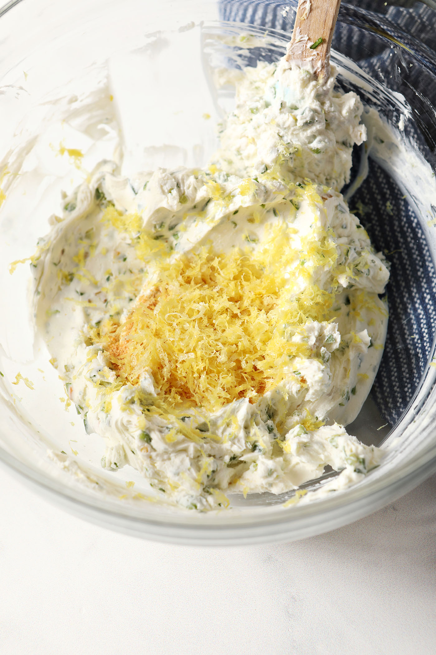 Lemon zest on top of Jalapeno Cream Cheese in a bowl, before mixing