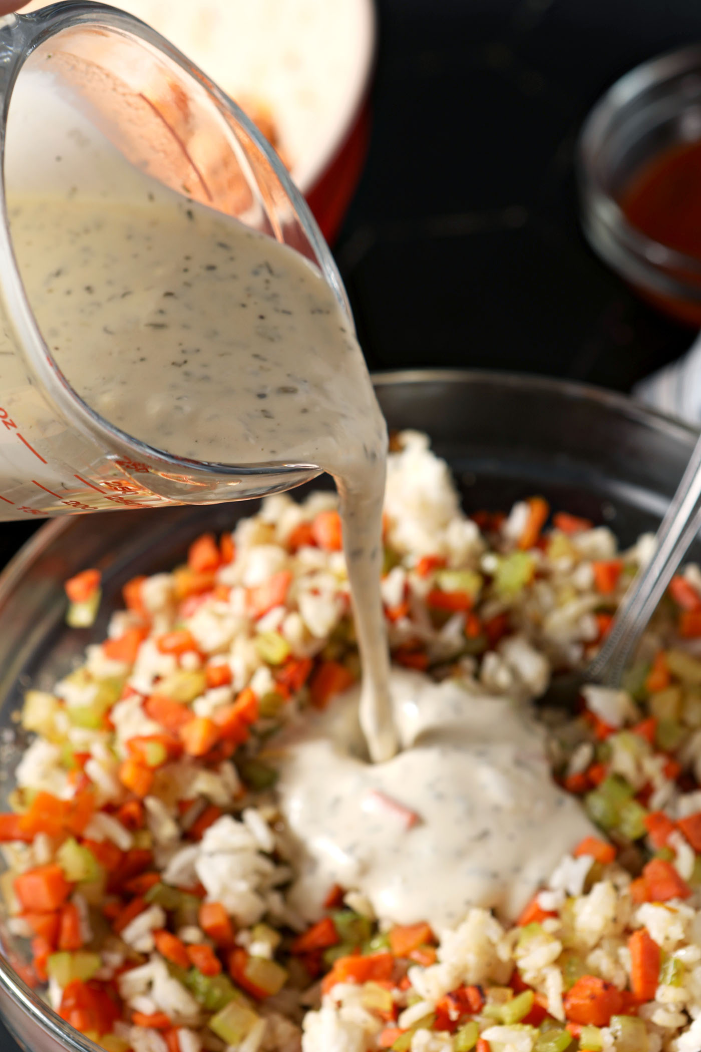 Ranch dressing pours on top of a rice mixture in a bowl