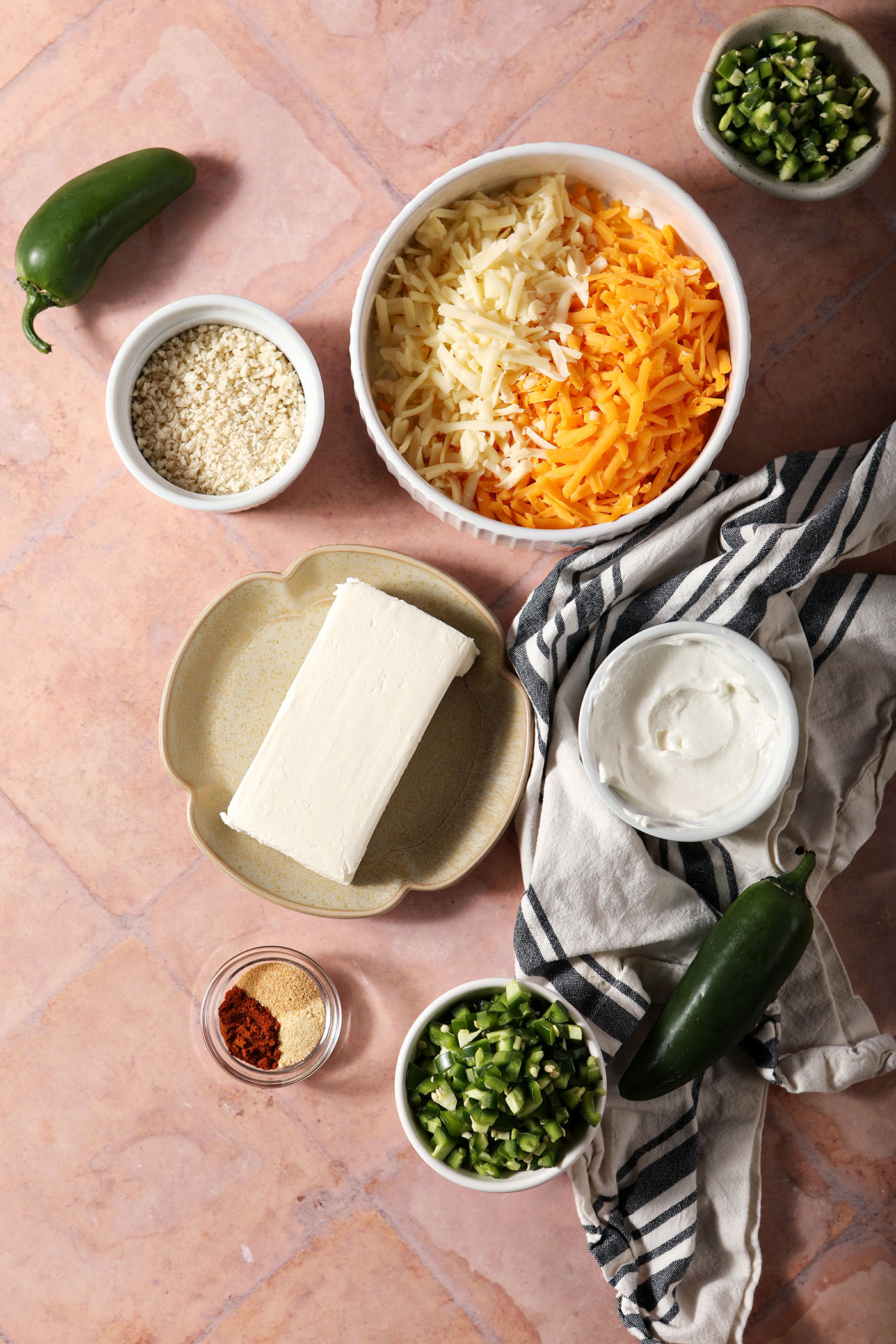 Ingredients to make jalapeno popper dip recipe in bowls on a terracotta tiled surface