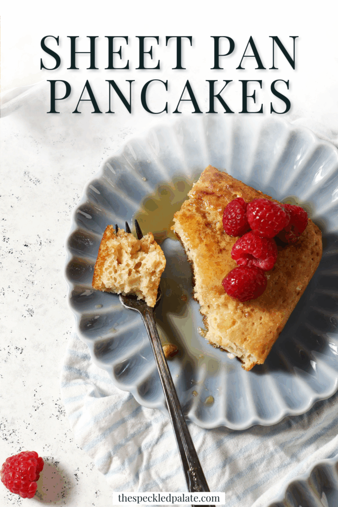 A fork holds a bite of a square pancake on a blue plate with the text sheet pan pancakes