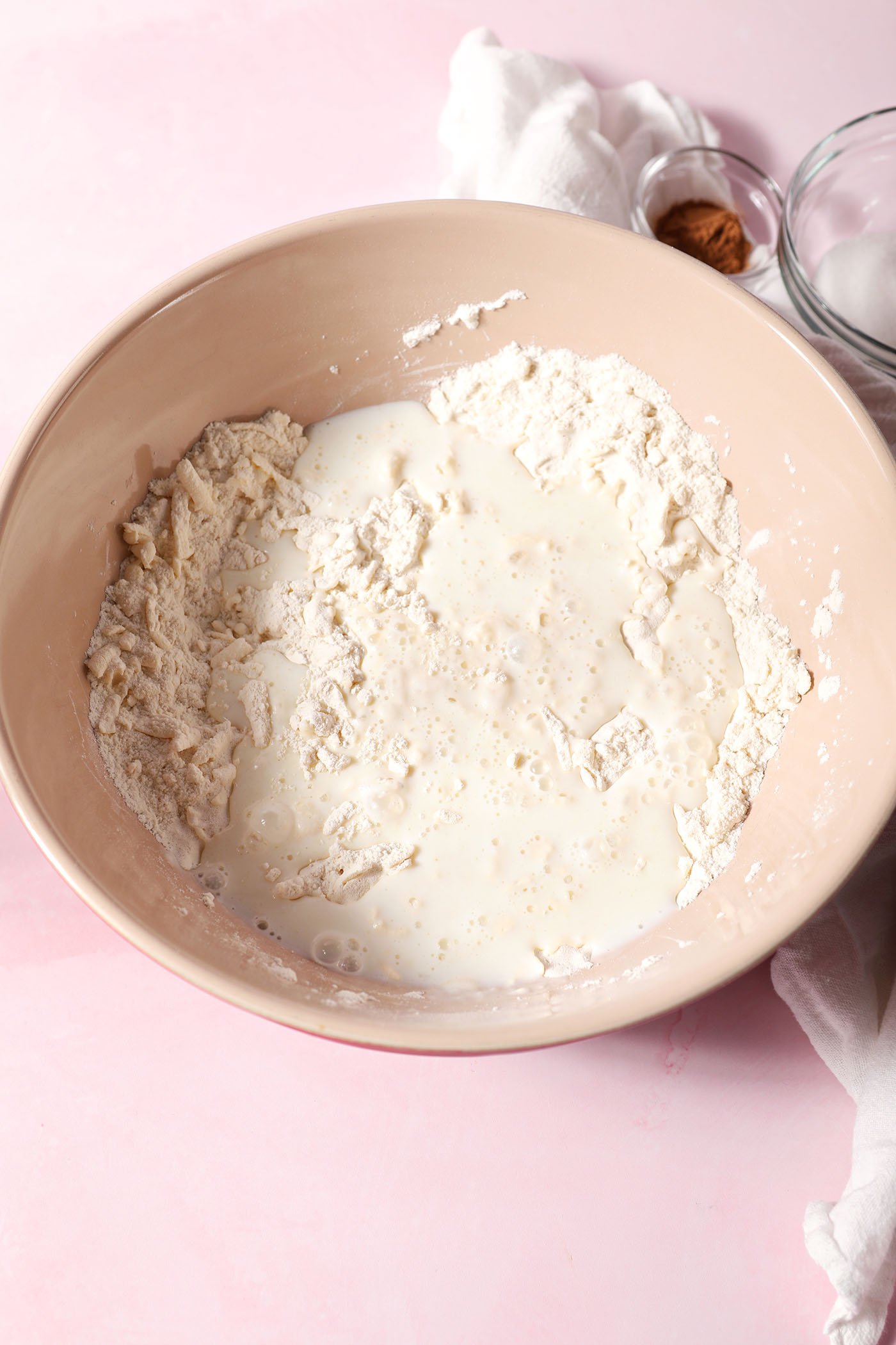Buttermilk sits on top a butter-flour mixture in a large bowl on a pink surface