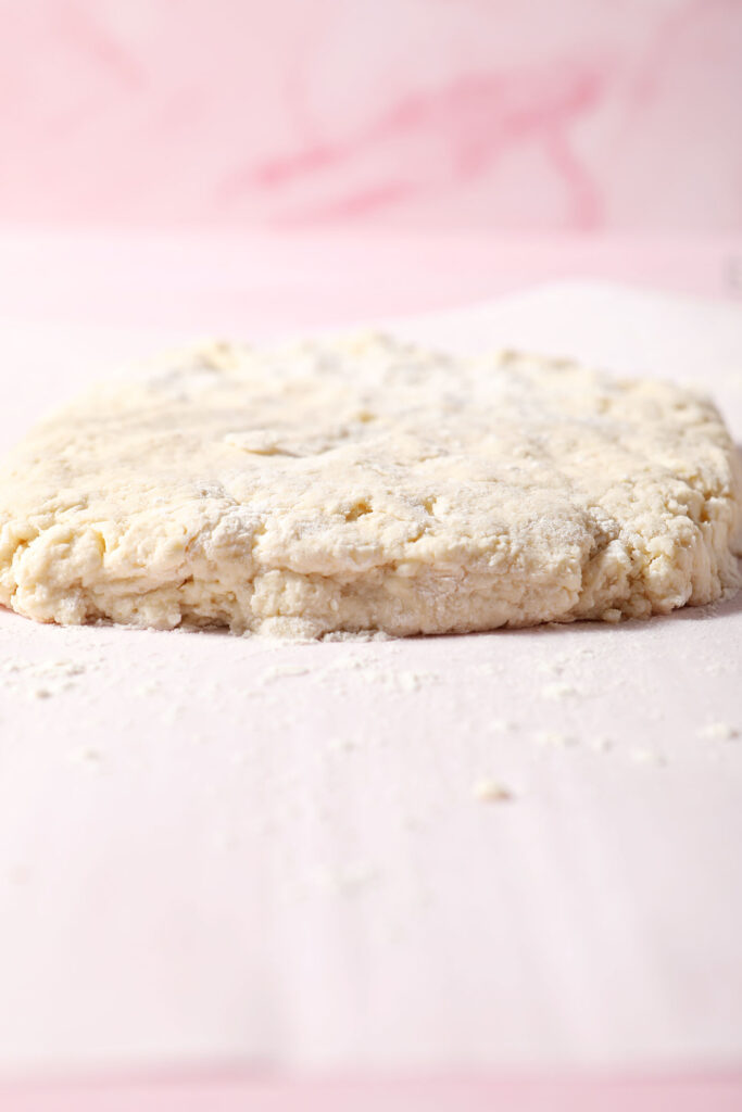 Side angle of a shaggy biscuit dough on a floured surface