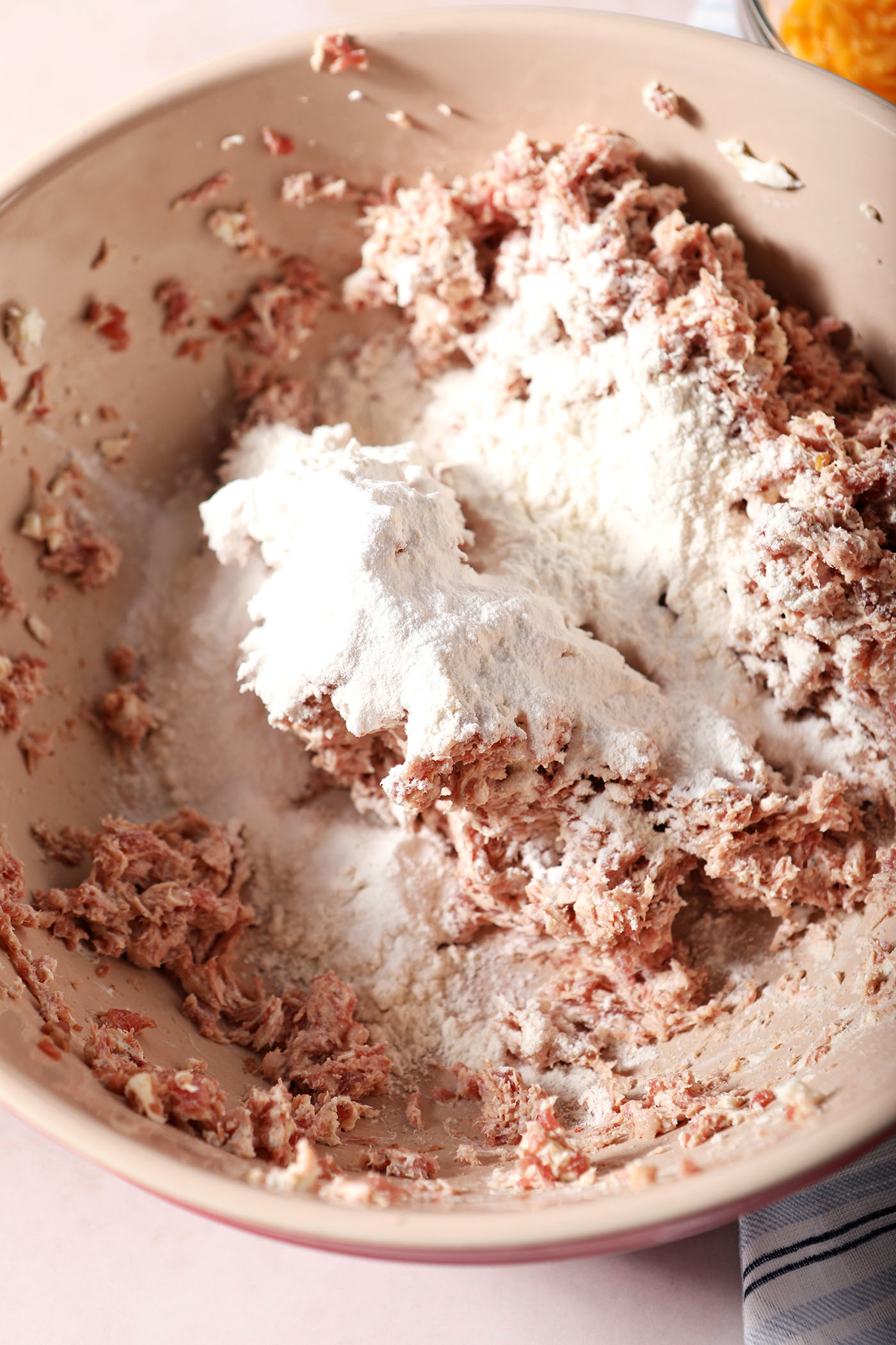 Homemade pancake mix on top of the sausage mixture in a bowl