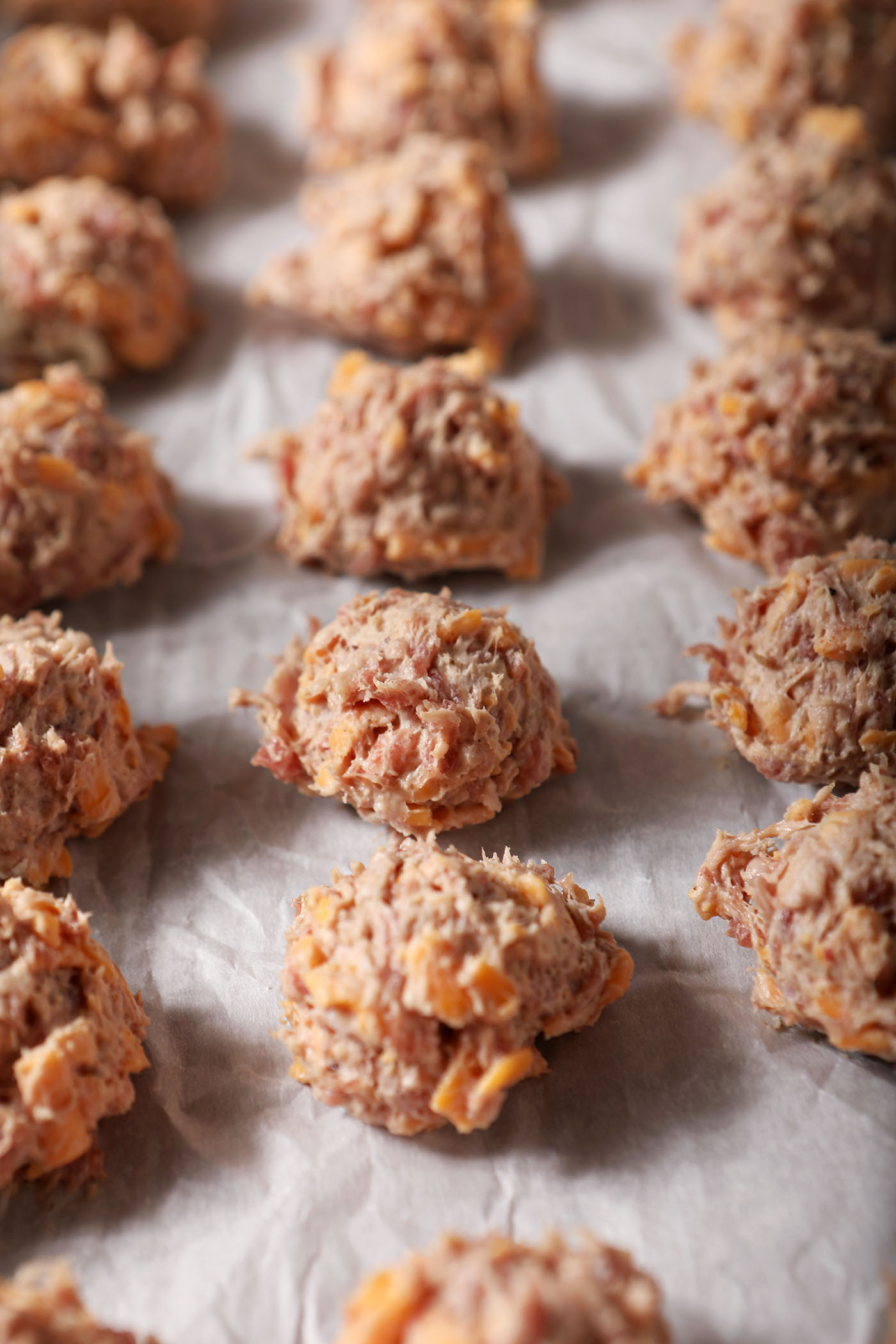 Scooped sausage balls on a sheet pan before baking