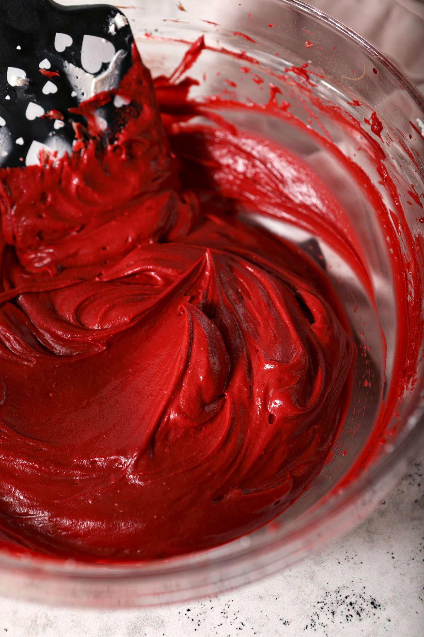Creamy Red Velvet Cheesecake Dip in a bowl with a black spatula