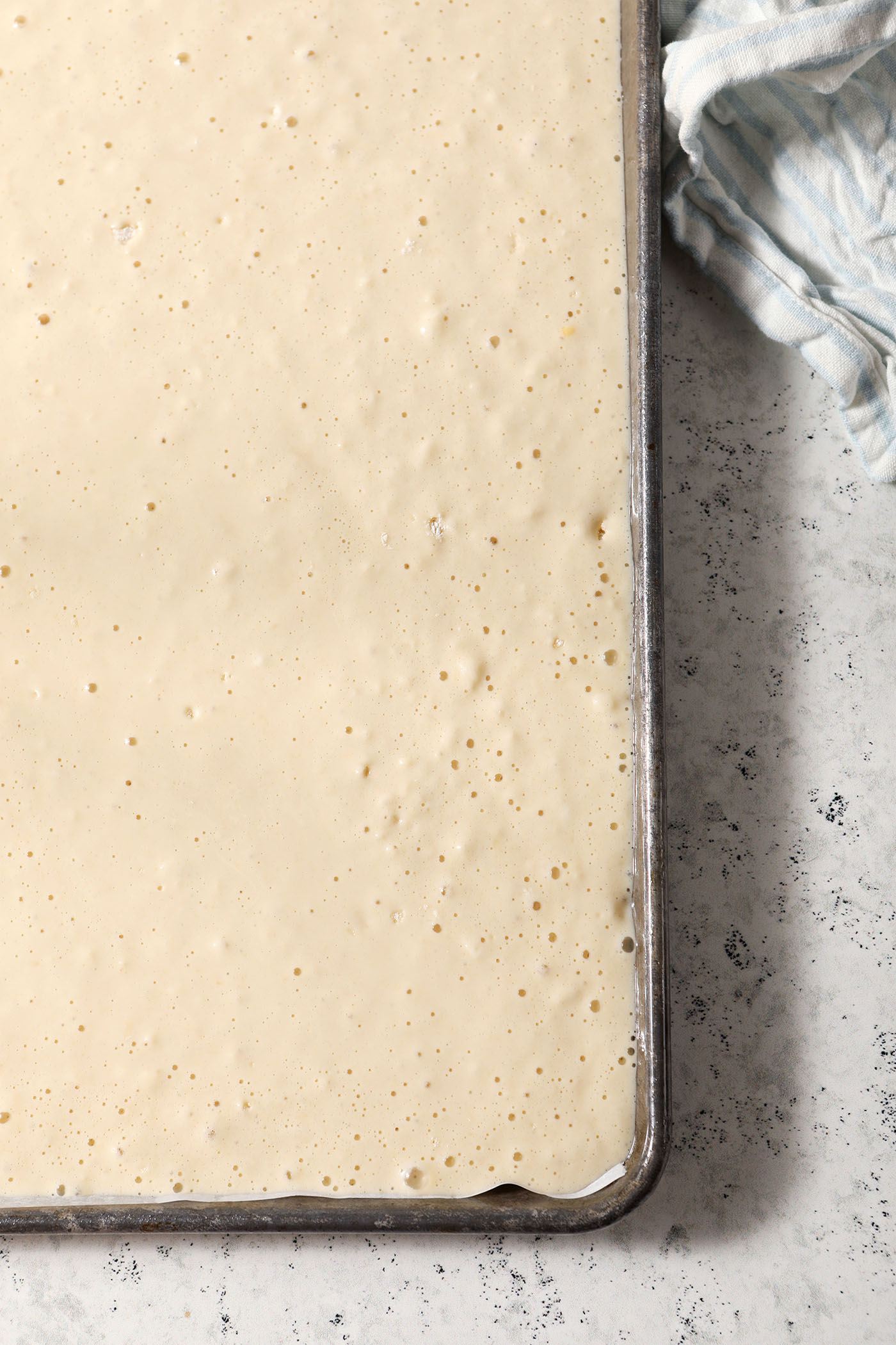 Pancake batter in a jelly roll pan before baking