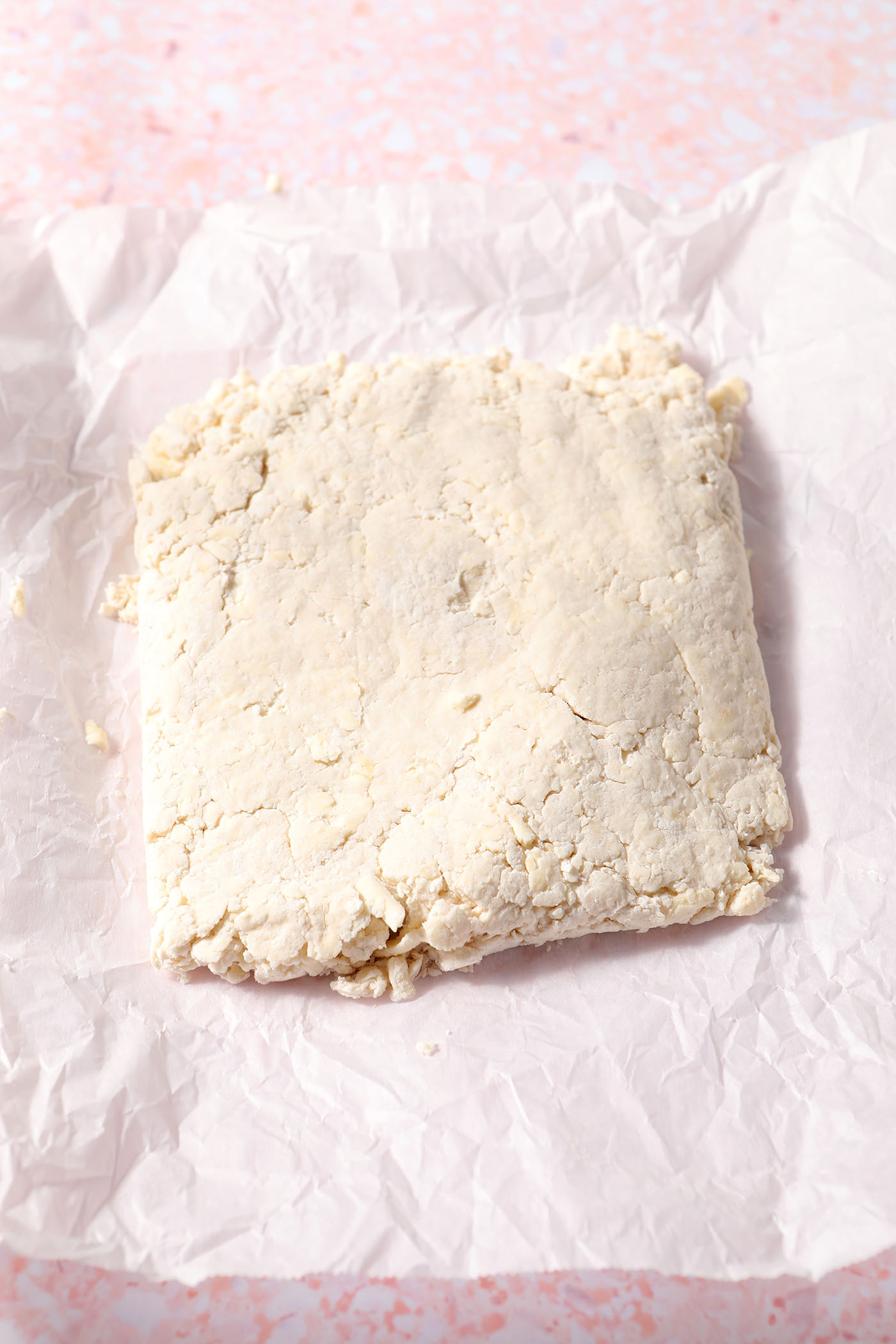 A square of biscuit dough on parchment paper