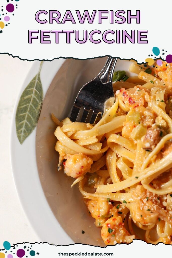 Overhead of a fork in a bowl of creamy crawfish pasta with the text crawfish fettuccine
