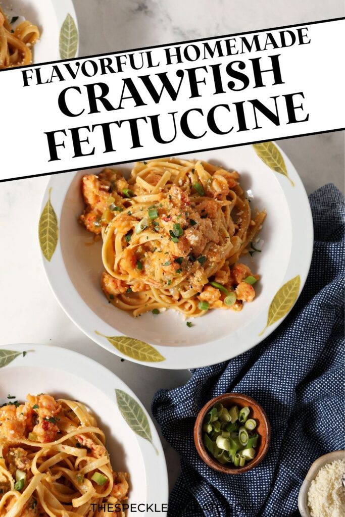 Overhead of three bowls of crawfish pasta garnished with green onions, parsley and parmesan on marble next to a blue linen with the text flavorful homemade crawfish fettuccine