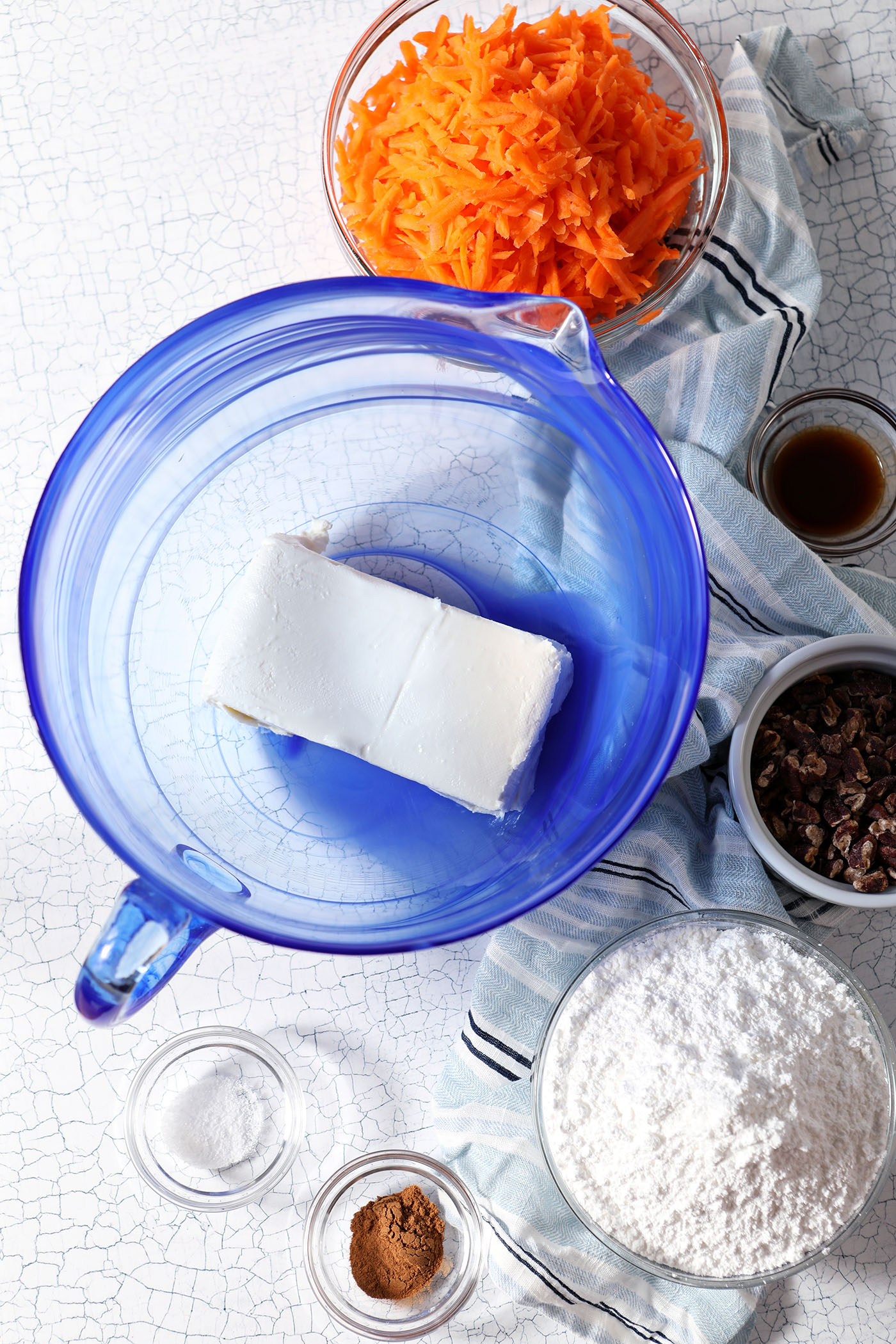 Ingredients to make carrot cake dip in bowls on a stone surface