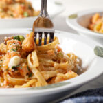 A fork swirls into a bowl of crawfish fettuccine