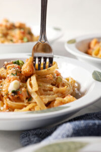 A fork swirls into a bowl of crawfish fettuccine