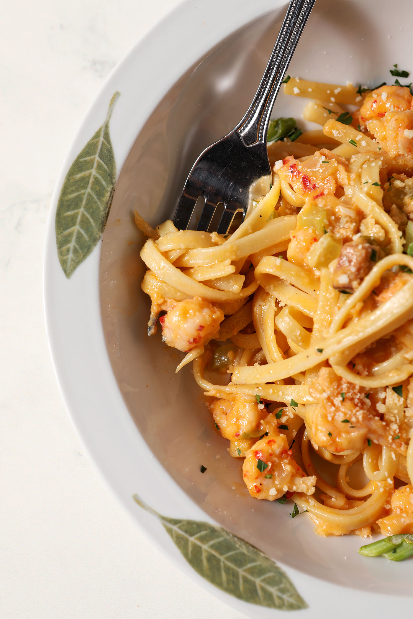 Overhead of a fork in a bowl of crawfish fettuccine