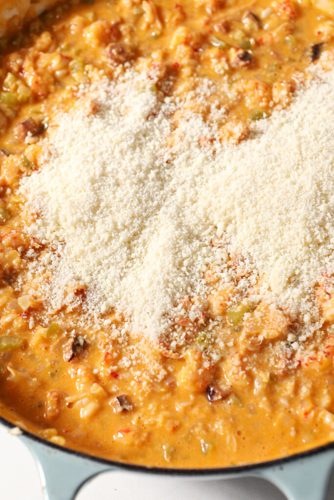 Parmesan cheese on top of an orange crawfish sauce
