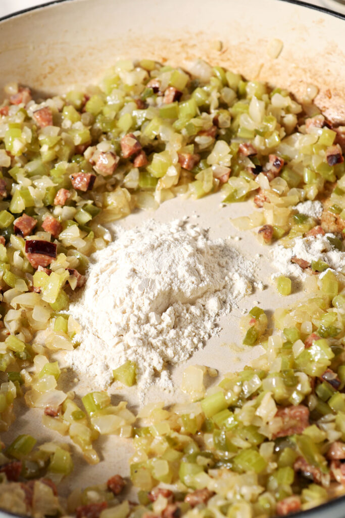 Flour in the center of sautéed vegetables before stirring together