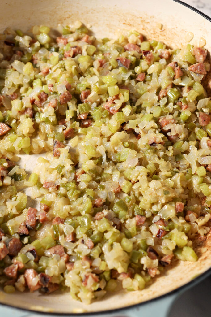 Vegetables mixed into a blonde roux in a pan