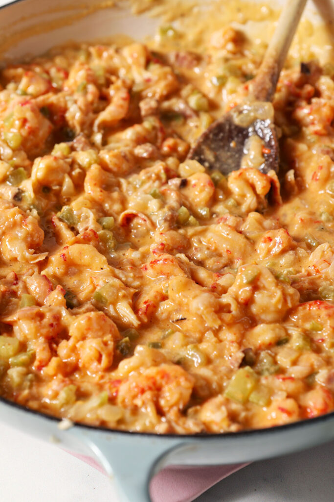 A sauce with lots of crawfish tails in a pan