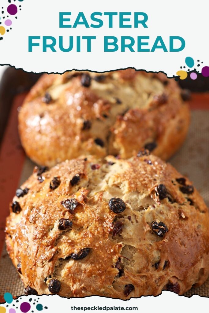 Two loaves of fruit bread for easter sit next to each other on a sheet pan after baking with the text easter fruit bread
