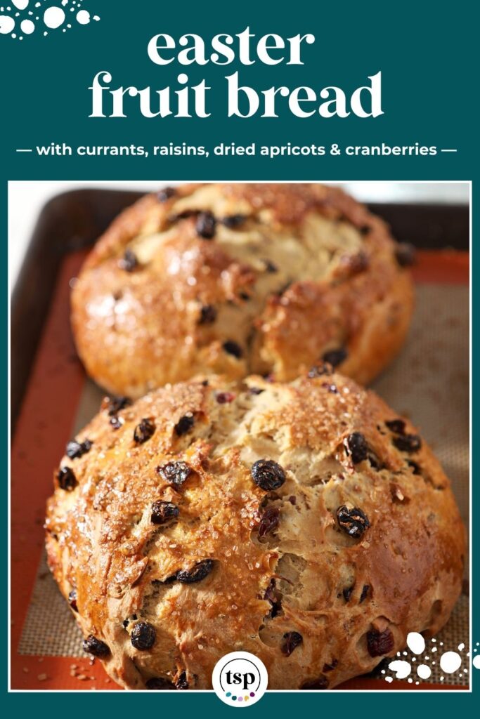 Two loaves of fruit bread for easter sit next to each other on a sheet pan after baking with the text easter fruit bread with currants, raisins, dried apricots & cranberries
