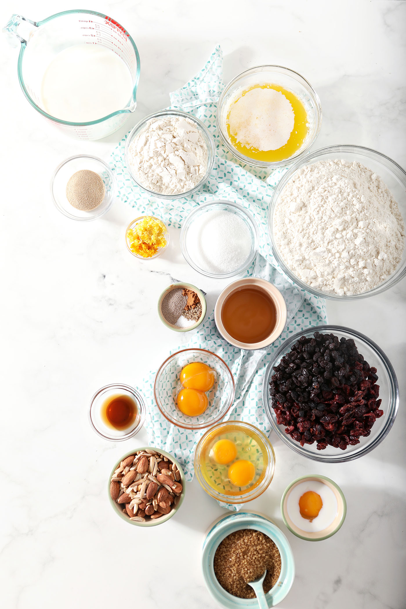 Ingredients to make easter bread in bowls on a white stone surface