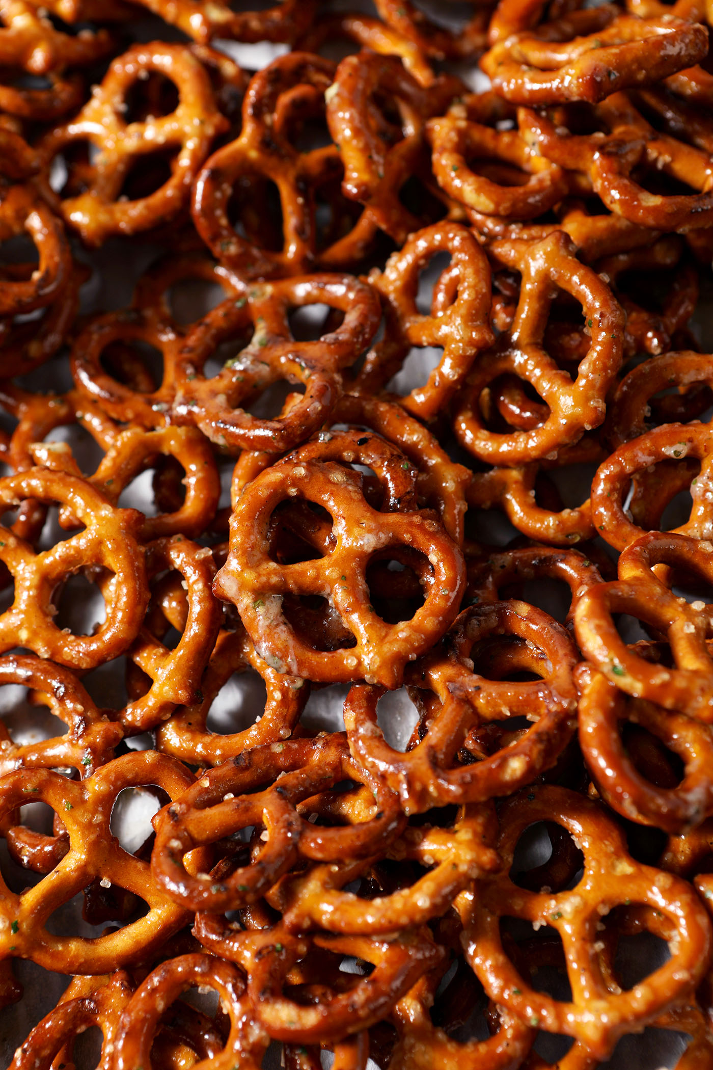 Crispy pretzels coated in butter and ranch dressing mix on a sheet pan, before baking