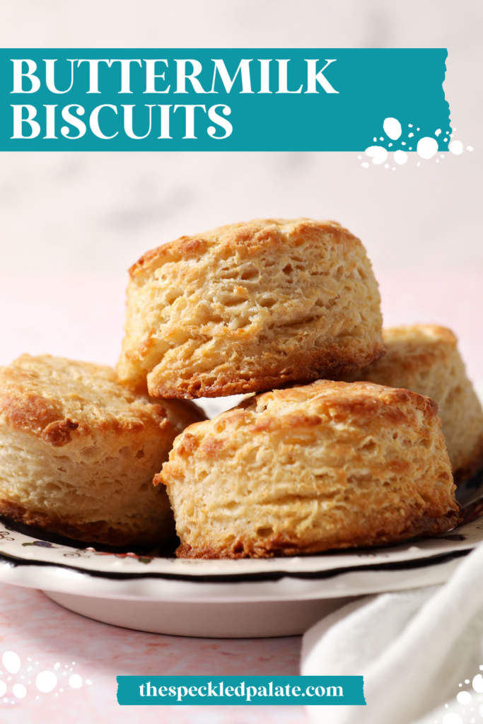 A plate of buttermilk biscuits stacked on a plate on a pink surface with the text buttermilk biscuits
