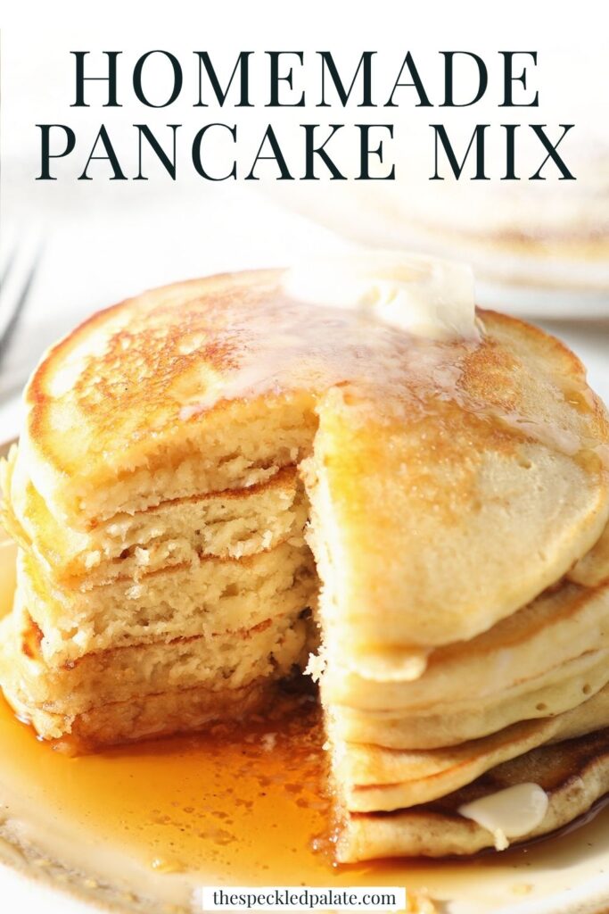 A cut-into stack of pancakes topped with melted butter and maple syrup on a plate on a marble surface with the text homemade pancake mix