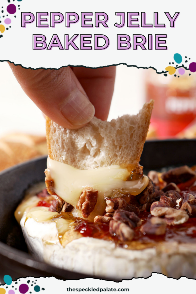 A baguette round is lifted out of a skillet holding Baked Brie with Pepper Jelly and Toasted Pecans with the text pepper jelly baked brie