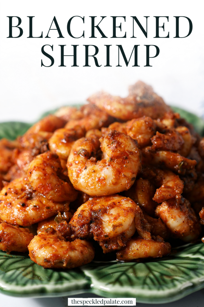 Blackened shrimp piled high on a green plate with text "Blackened Shrimp"