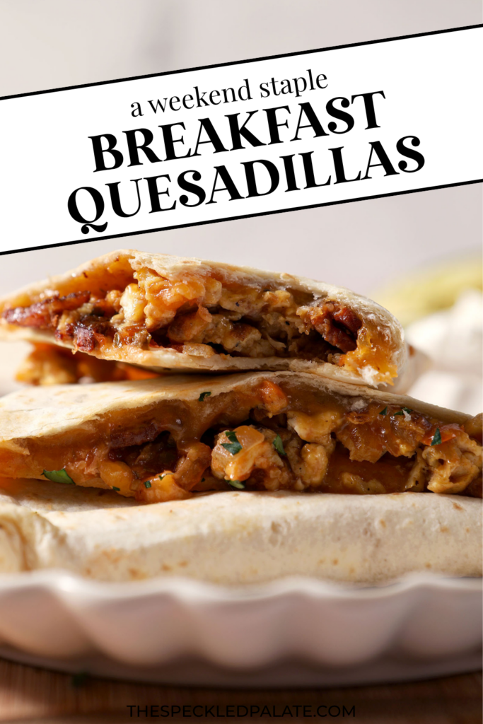 Breakfast quesadillas stacked on a plate on top of a wooden cutting board next to bowls of salsa and sour cream and an avocado. With the Text "Breakfast Quesadillas. Perfect for Hosting." written across the top.