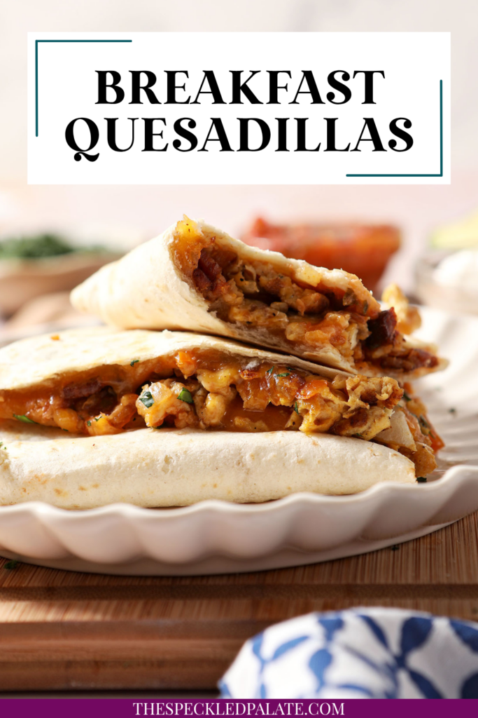 Breakfast quesadillas stacked on a plate on top of a wooden cutting board next to bowls of salsa and sour cream and an avocado. With the Text "Breakfast Quesadillas. Perfect for Hosting." written across the top.